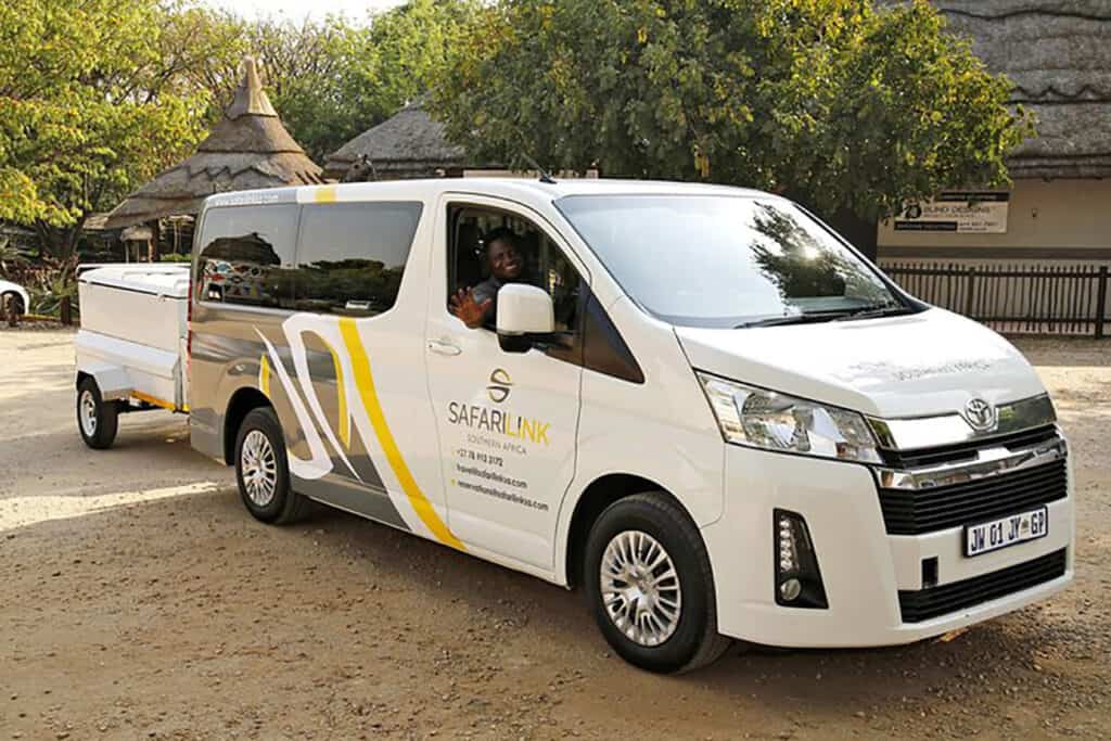 Safarilink SA white passenger van with logo and yellow stripe.
